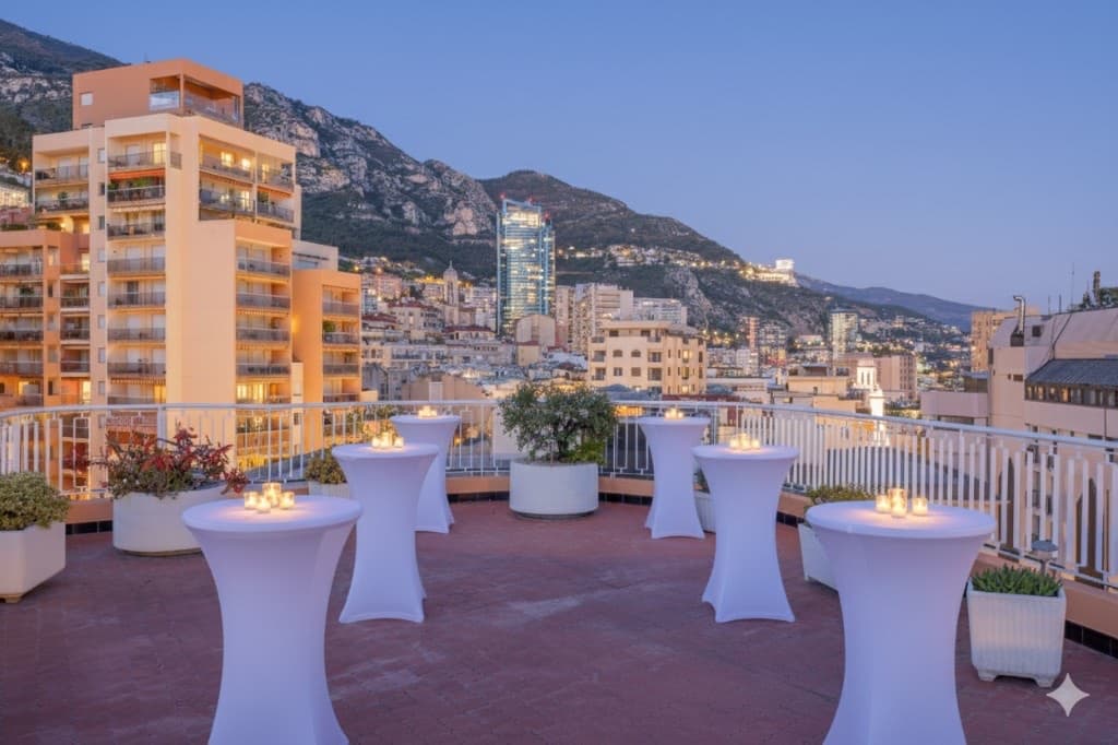 Cocktail reception set up with candlelit high-top tables on the Monte-Carlo rooftop terrace at dusk